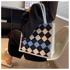 Detail of blue and white argyle knit tote bag with thick woven straps for women