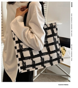 Detailed view of hand-drawn black and white checkered canvas tote bag with shoulder straps