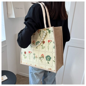 Detail of floral tote bag with jute stitching and elegant pearl decorative chain