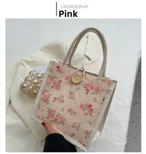 Detailed close-up of pink floral embroidery lunch bag with rustic wooden button closure