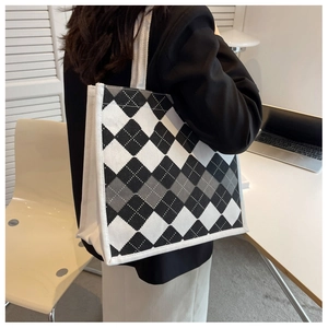 Close-up of a large argyle tote bag showing side detail and white braided handles