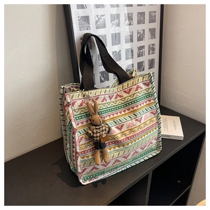 Close-up of ethnic geometric canvas tote bag with woven strap and cute plush bunny charm