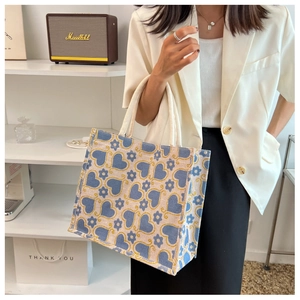Detailed view of canvas tote bag with blue heart floral pattern and cotton rope handles