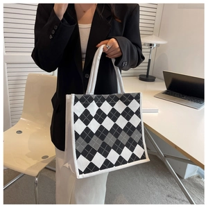 Detail of diamond pattern tote bag with woven handles on an office desk setting