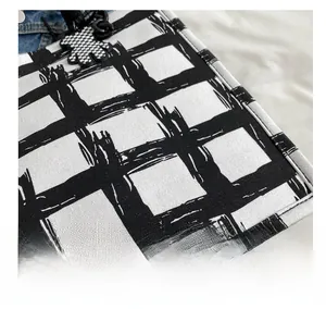 Detail of hand-painted checkered canvas tote with a cute bear charm and textured fabric