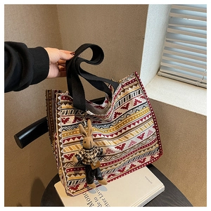 Close-up of canvas tote bag with tribal geometric patterns and a bunny charm