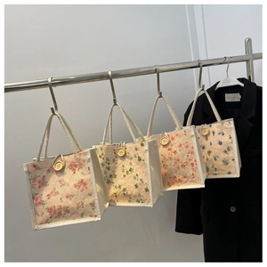 Detailed close-up of embroidered floral lace tote bags with wooden button and rope handles