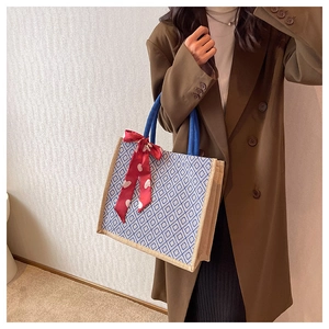 Detailed view of linen tote bag with blue geometric pattern and red heart silk scarf