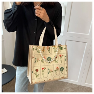 Close-up of floral linen tote bag with grid pattern and decorative pearl handle chain