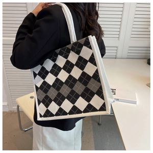 Side view of large checkerboard tote bag with white rope handles on a model