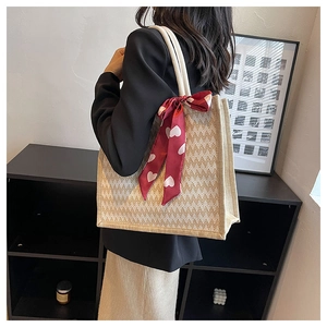 Détail du cabas en lin à chevrons avec un foulard en soie rouge à motifs de cœurs