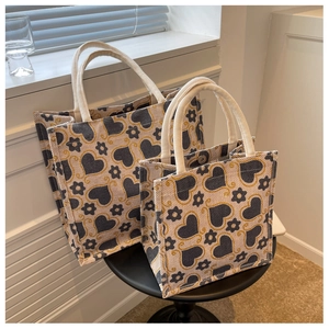 Detail of high-capacity tote bags with heart patterns and white cotton rope handles
