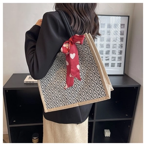 Detail of linen tote bag with geometric diamond pattern and red heart ribbon