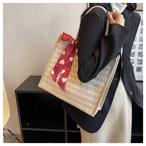 Détail du sac cabas en lin avec motif à chevrons et ruban en soie rouge à motifs cœurs