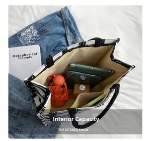 Large capacity canvas tote bag showing interior space with a tablet, bottle, and umbrella