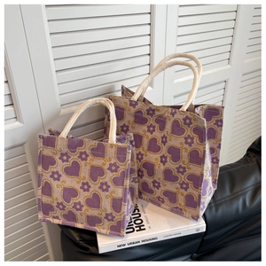 Detail view of large and small purple heart jute tote bags with rope handles