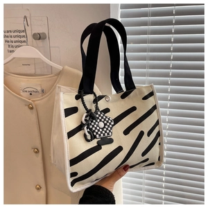Detailed macro view of the zebra-patterned canvas bag with a checkered flower charm