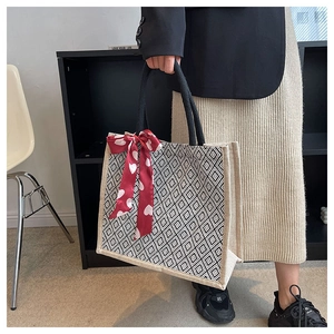Detail of linen tote bag with geometric diamond pattern and red heart silk scarf handle