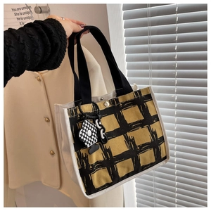 Detail of canvas tote with yellow black plaid pattern and checkerboard charm