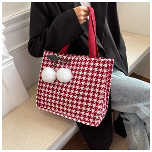 Detail der roten Houndstooth-Tragetasche mit Kirschanhänger und Canvas-Griffen