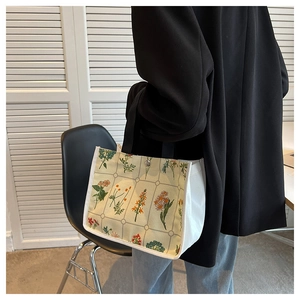 Detail of canvas tote bag showing colorful floral pattern and silver magnetic snap closure