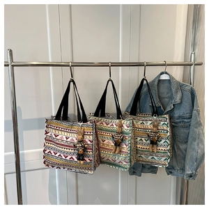 Detailed shot of ethnic canvas tote bags with geometric prints and rabbit plush charm
