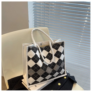 Detail of checkered canvas tote bag with woven rope handles and magnetic snap closure