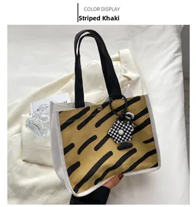 Detail of striped canvas handbag featuring tiger print and checkerboard flower charm