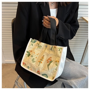 Detail of floral canvas tote bag with black mesh print and metal snap button closure