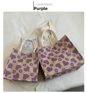 Close-up of purple heart-patterned woven tote bags with braided rope handles