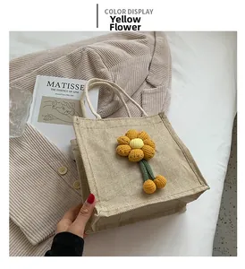 Close-up of burlap tote bag featuring a 3D yellow crocheted flower detail on the front
