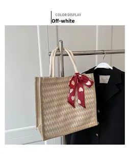 Détail du cabas en lin crème avec texture en V et foulard en soie à motif cœur rouge