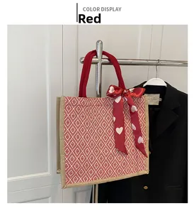 Detail of red geometric woven tote bag with a heart print silk scarf on a metal hanger