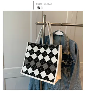 Detail of cream white argyle pattern tote bag made of durable canvas material