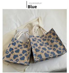 Detailed comparison of large and small woven tote bags with blue heart pattern