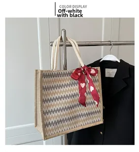 Détail du cabas en lin avec rayures zigzag noires et foulard en soie rouge à motifs cœurs