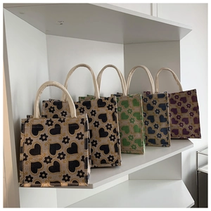 Detail view of large capacity jute tote bags with heart floral patterns and cotton rope handles