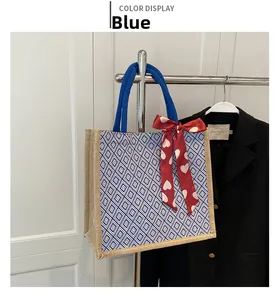 Close-up of blue diamond pattern linen tote bag with decorative silk scarf on wood