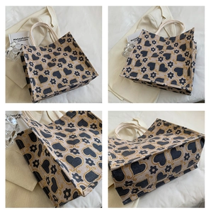 Detail of canvas tote bag with blue heart and floral print shown from multiple angles