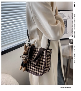 Detail view of mini checkerboard tote bag with cute rabbit charm and metal hardware