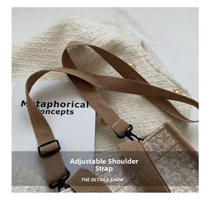 Detail view of adjustable woven shoulder strap and textured canvas bag craftsmanship