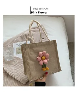 Detail of jute tote bag with 3D pink plush flower and rope handles on soft background