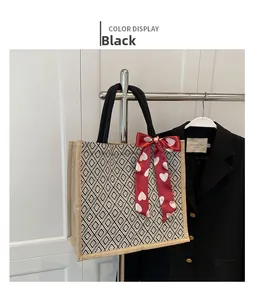 Detail of linen tote bag with black and white diamond weave and red heart ribbon