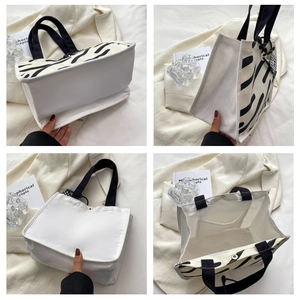 Detail view of canvas tote bag with zebra stripes, magnetic snap button and inner pocket