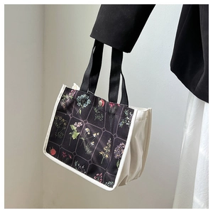 Detailed shot of canvas tote bag featuring colorful floral patterns and a metal snap button
