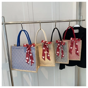 Detail of linen tote bags in four colors featuring heart print bows and round handles