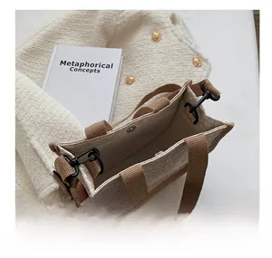 Detail view of canvas tote bag interior with magnetic snap button and brown strap