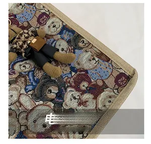 Detail of jacquard weave tote bag with teddy bear pattern and stitched reinforcement