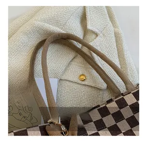 Detail showing checkered tote bag weave texture and brown braided rope handles