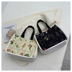 Detail of floral canvas tote bags with contrast white sides and black webbing handles
